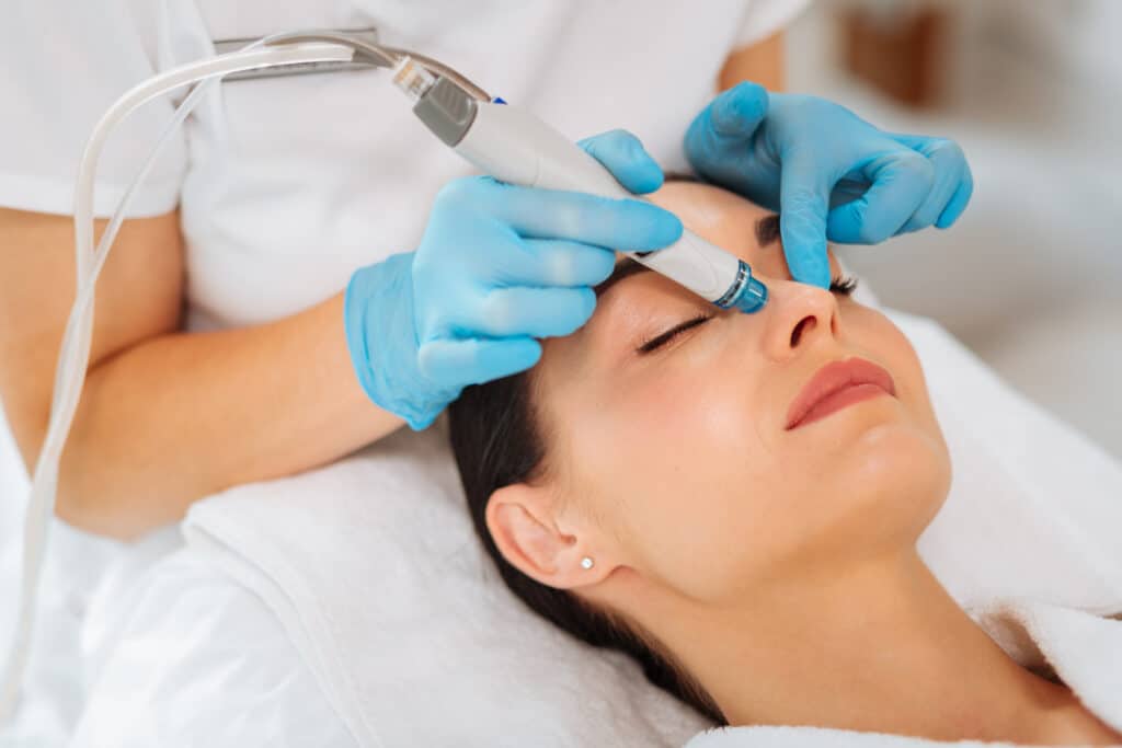 Woman with oily skin receiving a Hydrafacial to clear her pores and get healthier looking skin